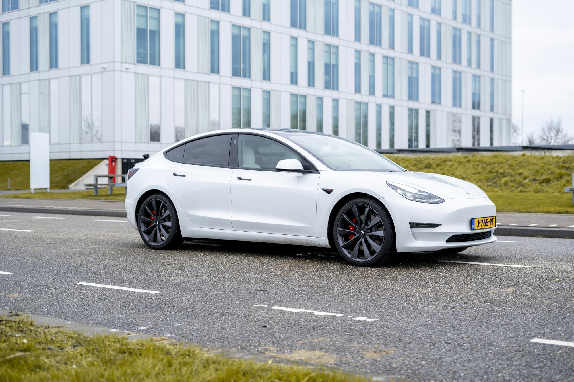 White Tesla Model 3 photographed from the front three-quarter angle.